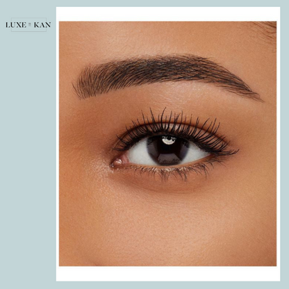 A close-up of a woman's eye showcasing long lashes, sculpted eyebrows, and smooth skin tone.
