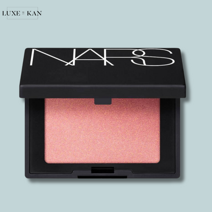 Close-up of a NARS mini blush in a sleek black compact with a soft pink shade.