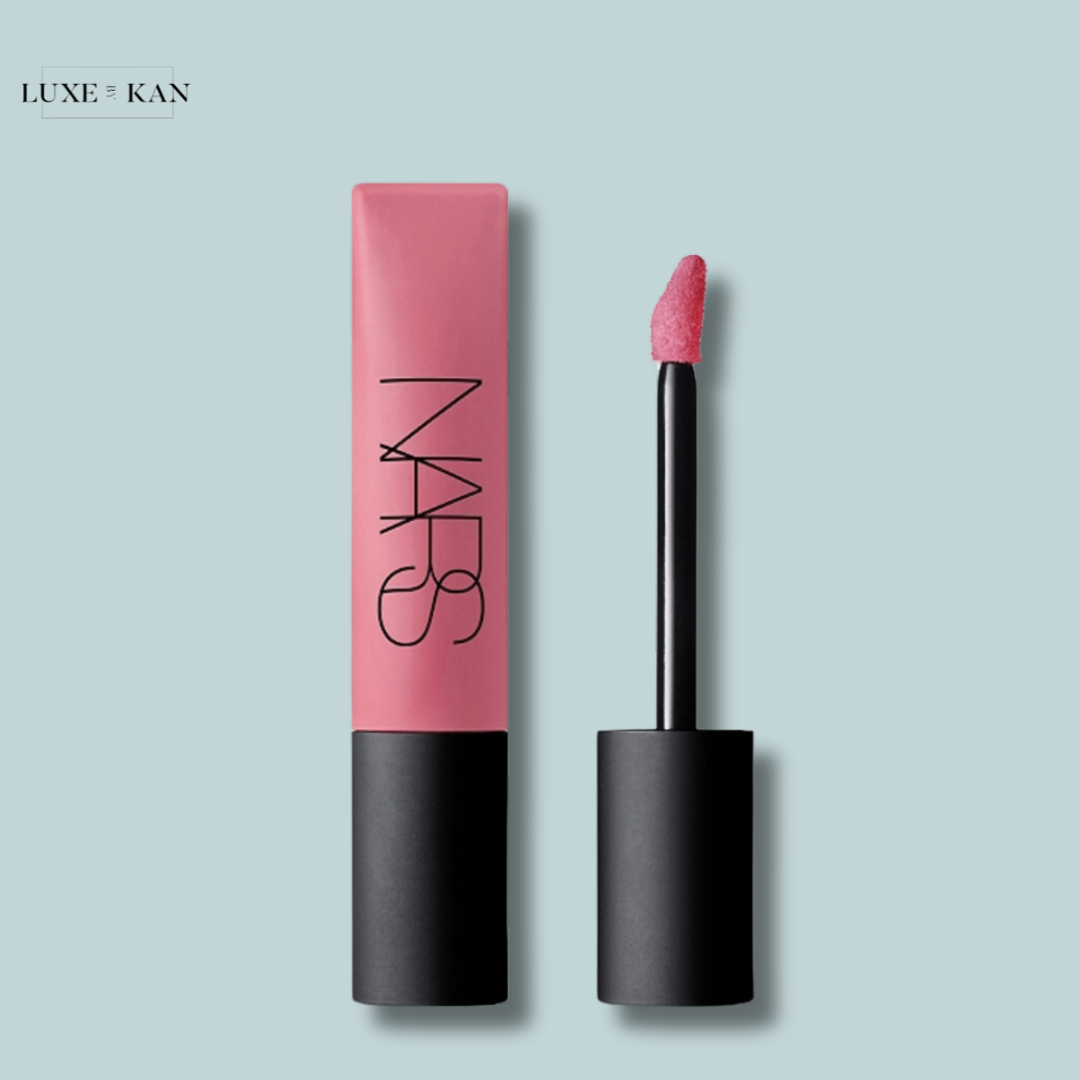 A pink NARS air matte lip colour tube with a sponge applicator stands upright next to it.