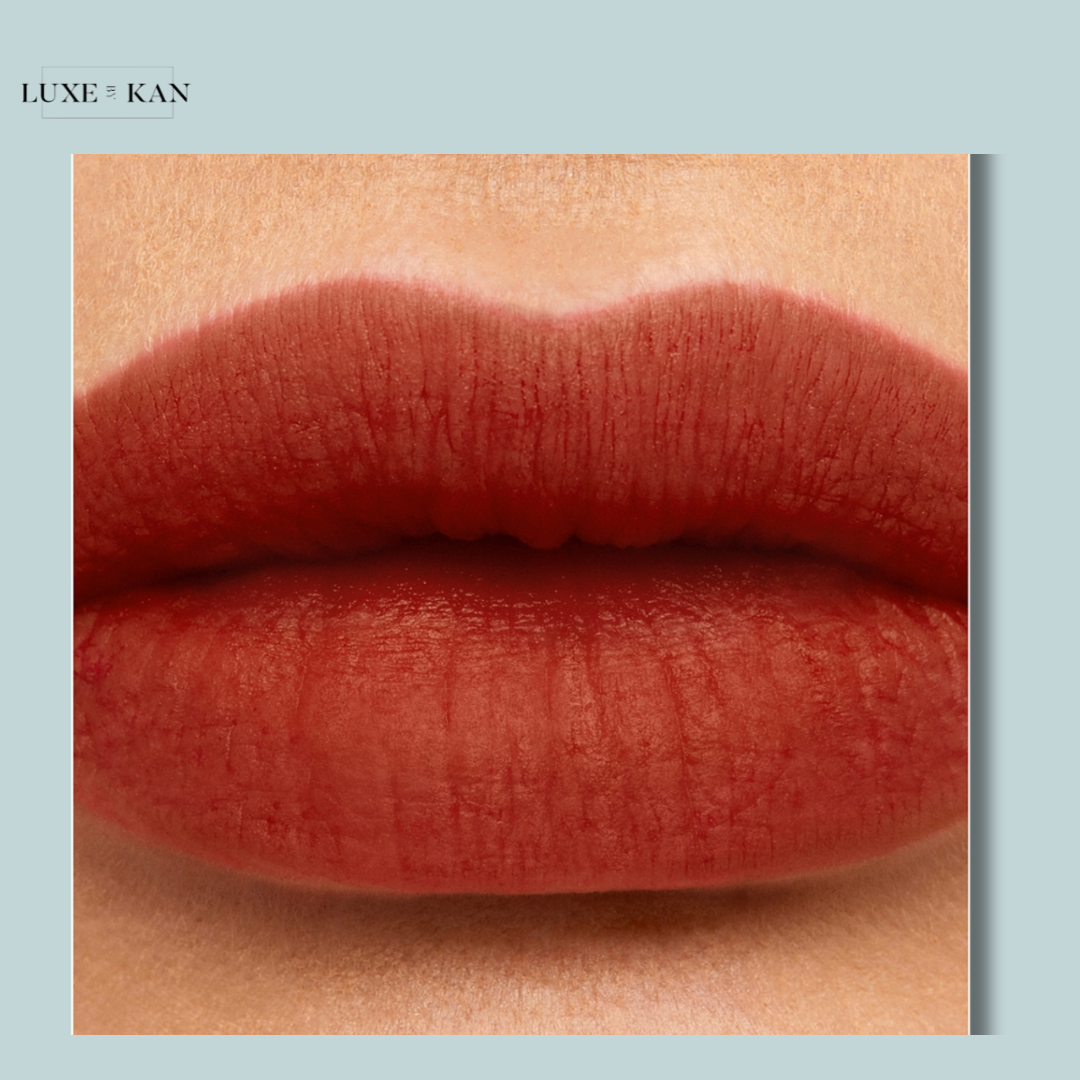 Close-up of plump, matte red lips against a soft backdrop, showcasing a rich lipstick color by Luxe & Kan.
