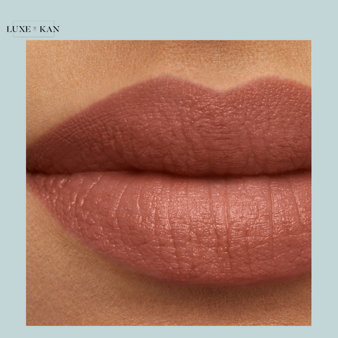 Close-up of beautifully defined, matte nude lips with a smooth texture, showcasing a soft, earthy color. Branding: Luxe & Kan.