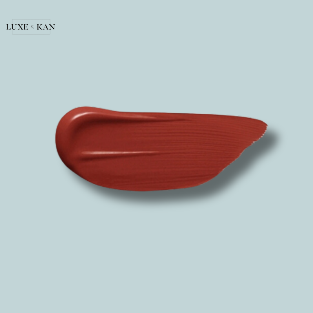 Smooth red lipstick swatch on a light blue background, showcasing a rich, glossy finish for a bold makeup look.