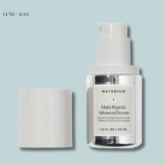 A silver bottle of Naturium Multi-Peptide Advanced Serum with a white pump, next to its cap.