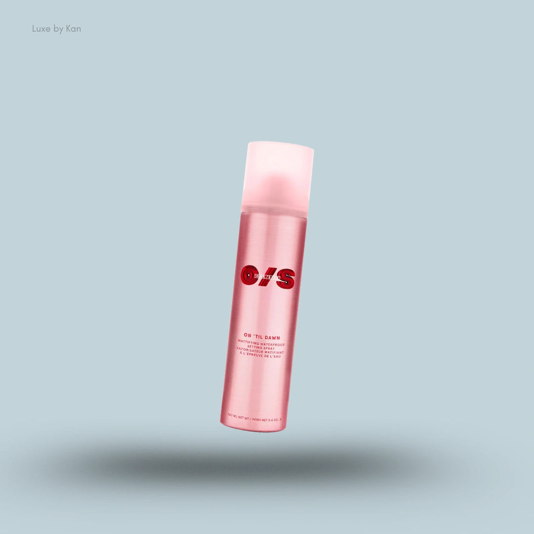 A pink bottle of ONESIZE On 'Til Dawn Mattifying Waterproof Setting Spray with a translucent pink cap, floating on a blue background.