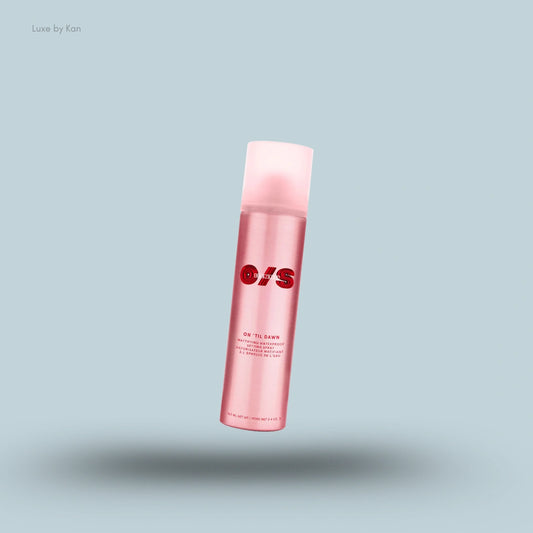 A pink bottle of ONESIZE On 'Til Dawn Mattifying Waterproof Setting Spray with a translucent pink cap, floating on a blue background.