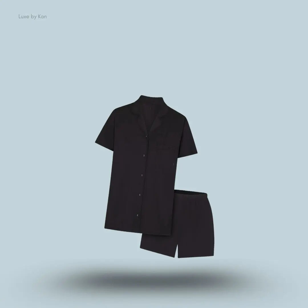 SKIMS Sleep Short Sleeve Button Up Set in Onyx, flat lay on light blue background