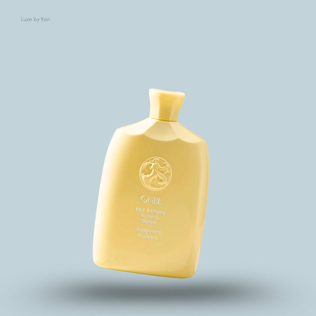 Oribe "Hair Alchemy Resilience Shampoo" in a yellow bottle with the brand's logo on a blue background.