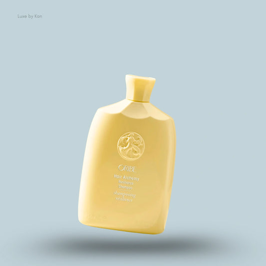 Oribe "Hair Alchemy Resilience Shampoo" in a yellow bottle with the brand's logo on a blue background.