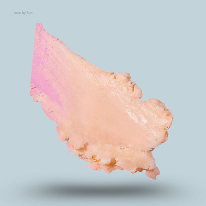 Close-up of a smear of Peace Out Retinol Eye Stick, showing a gradient from pink to cream, on a blue background.
