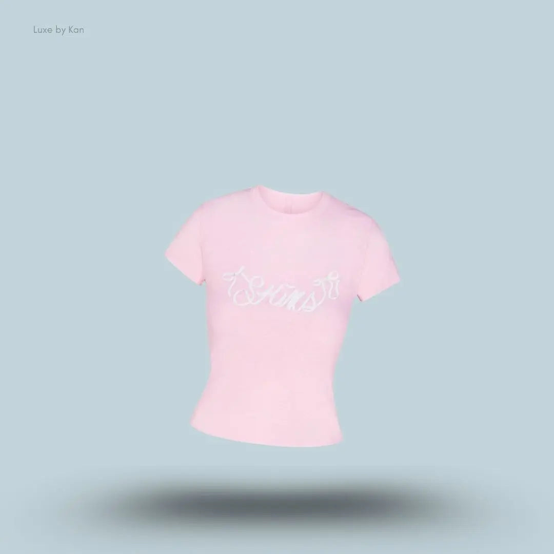 SKIMS Worn In Jersey T-Shirt in Peony Skims Bow, flat lay on light blue background