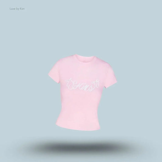 SKIMS Worn In Jersey T-Shirt in Peony Skims Bow, flat lay on light blue background