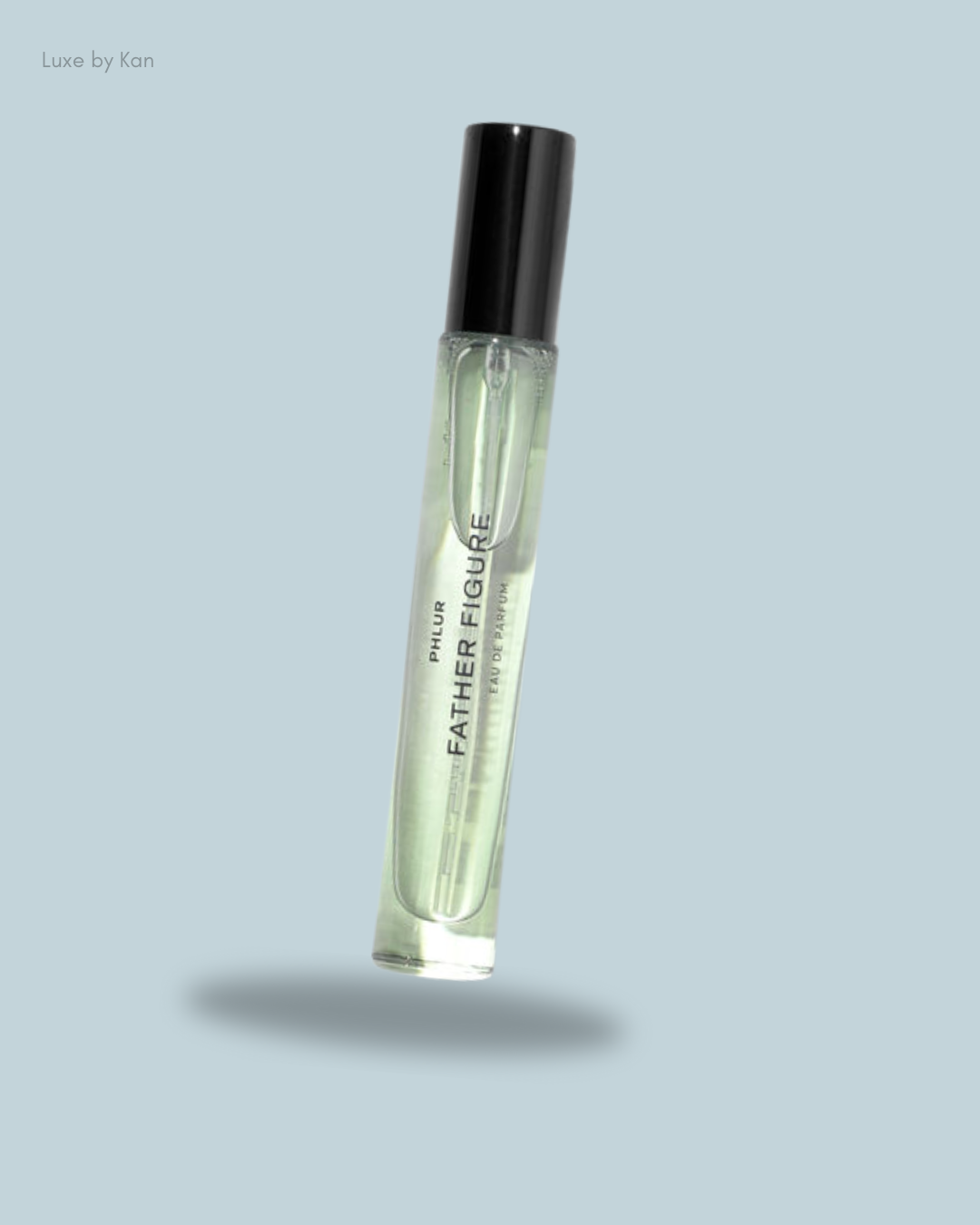 A floating bottle of Phlur Father's Figure Eau de Parfum, featuring a sleek design with a black cap and light green liquid.