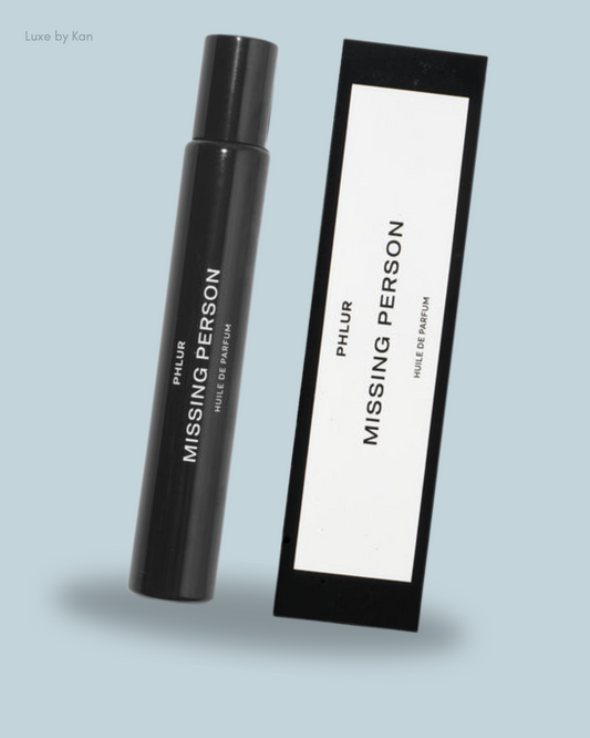 A black perfume bottle labeled "Missing Person" next to its matching box.