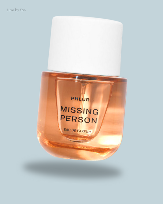 Phlur's "Missing Person" eau de parfum in a sleek amber bottle with a white cap.