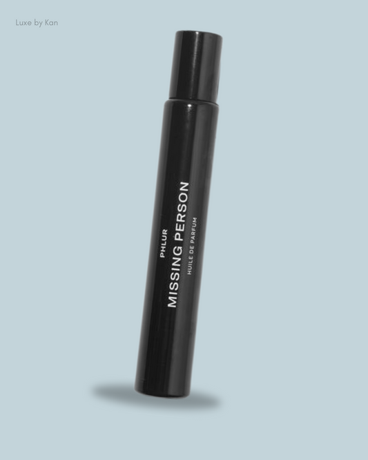 A sleek black perfume bottle labeled "Missing Person" by Phlur.