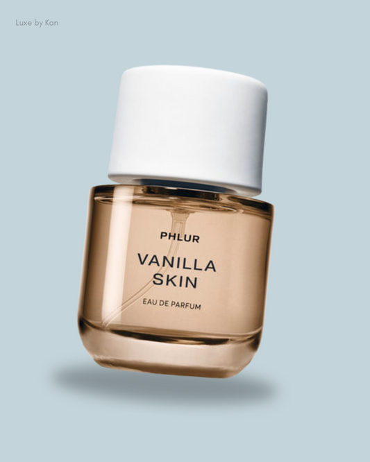 A bottle of PHlur Vanilla Skin Eau de Parfum with a minimalist design, featuring a white cap and light amber liquid.