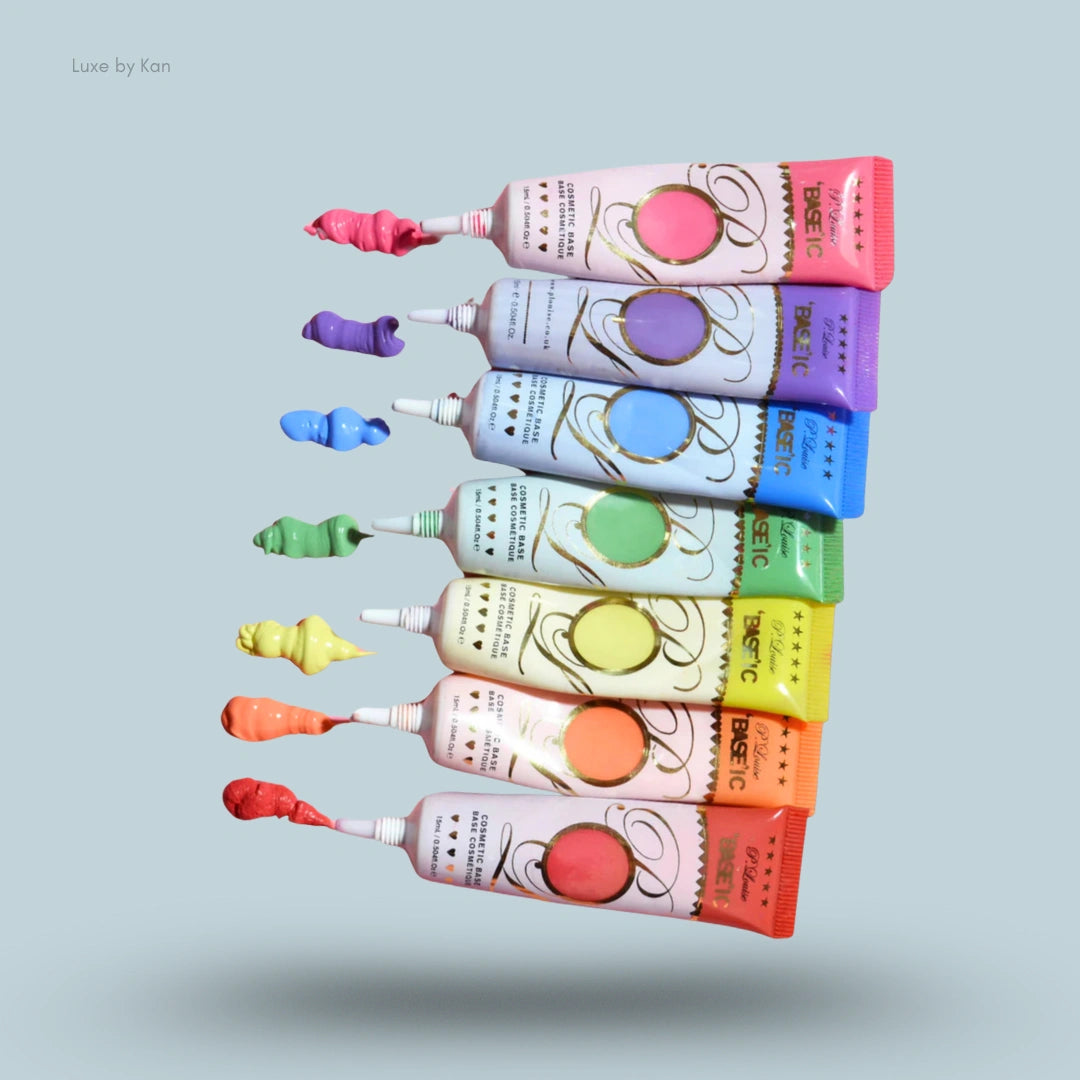 Seven tubes of Plouise Cosmetic Base arranged vertically in a rainbow gradient, with small dollops of corresponding colored base extending from their open ends.