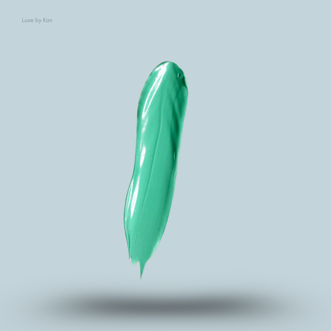 A smear of Plouise turquoise-colored cosmetic base against a light blue background, featuring a glossy texture.