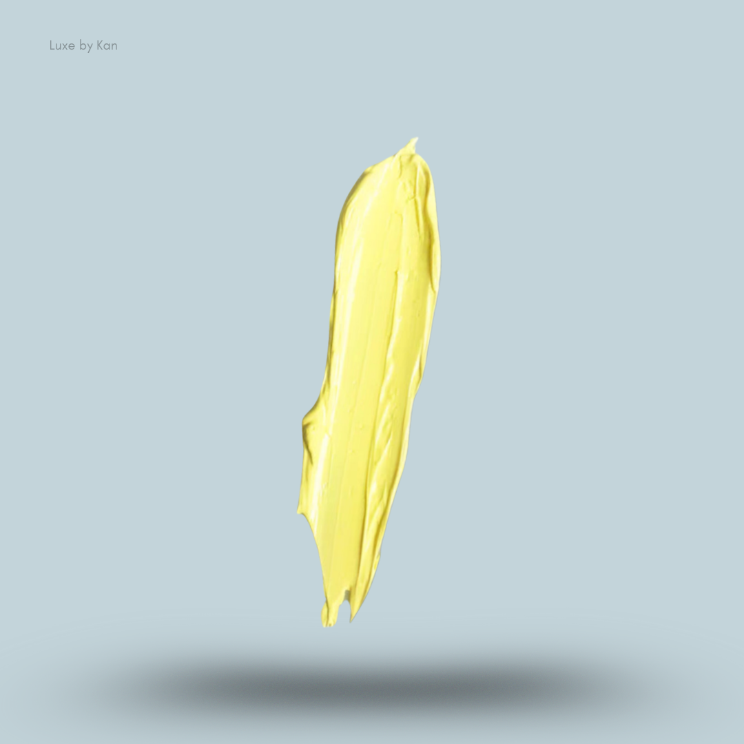 Swath of yellow Plouise makeup base against light blue backdrop.