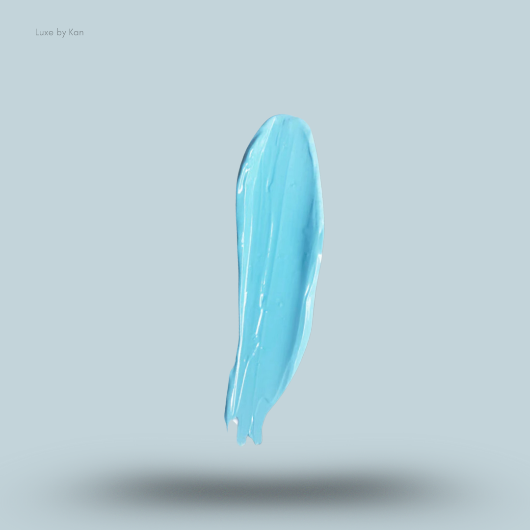 Smear of Plouise sky blue coloured base makeup on a light blue background.