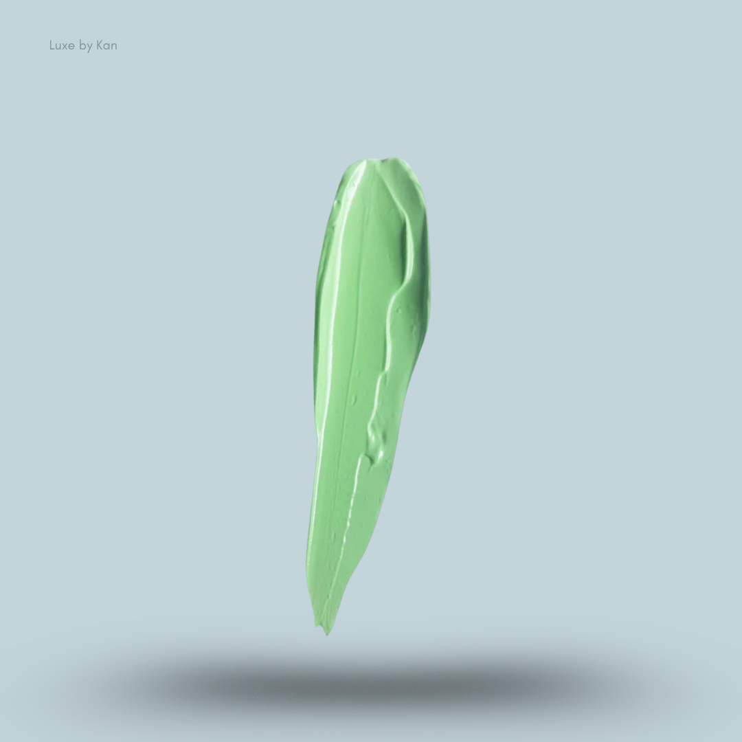 Vertical smear of light green Plouise makeup base against a pale blue background, casting a soft shadow.