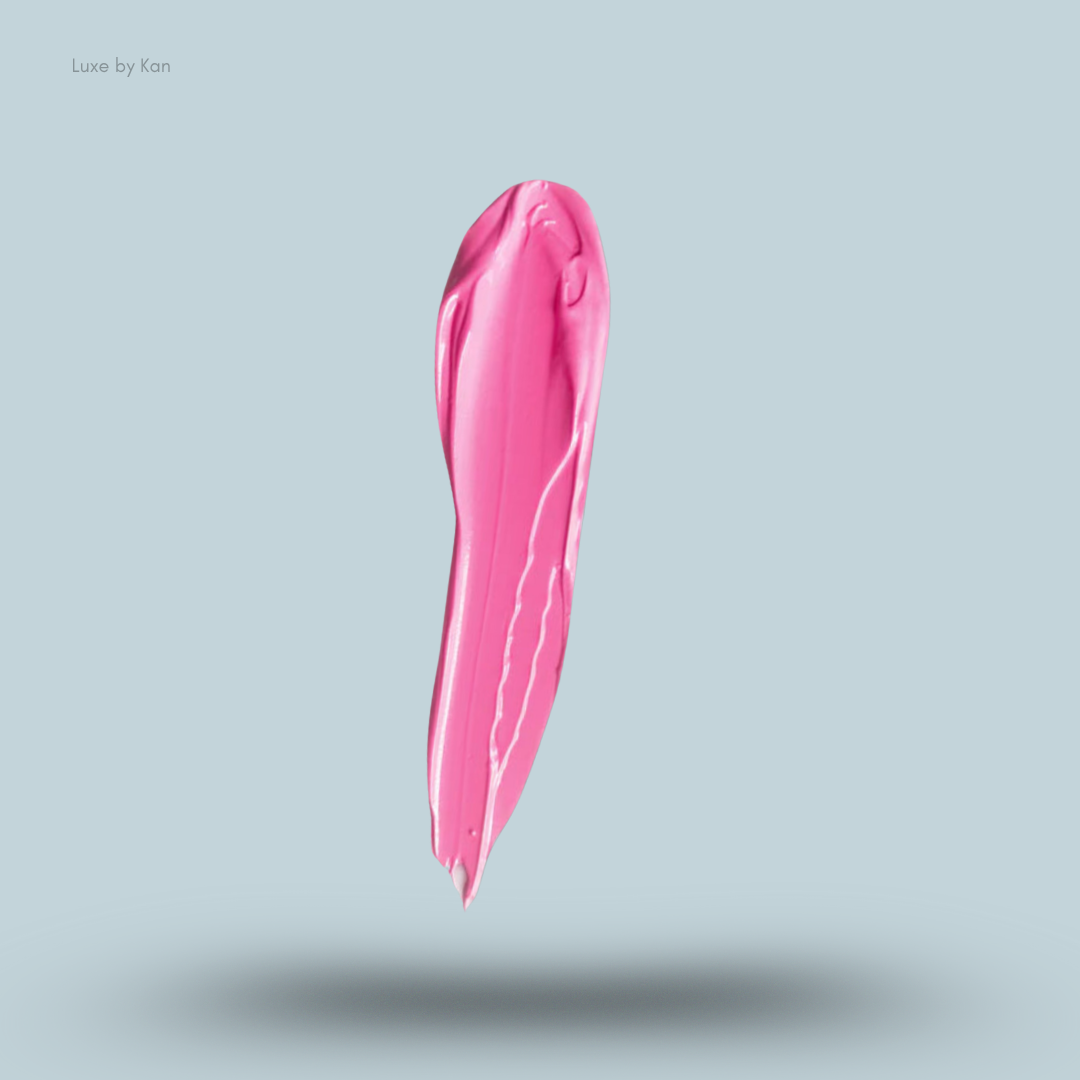 Close-up of a vivid pink cosmetic base, swiped to reveal a glossy texture, against a pale blue background.