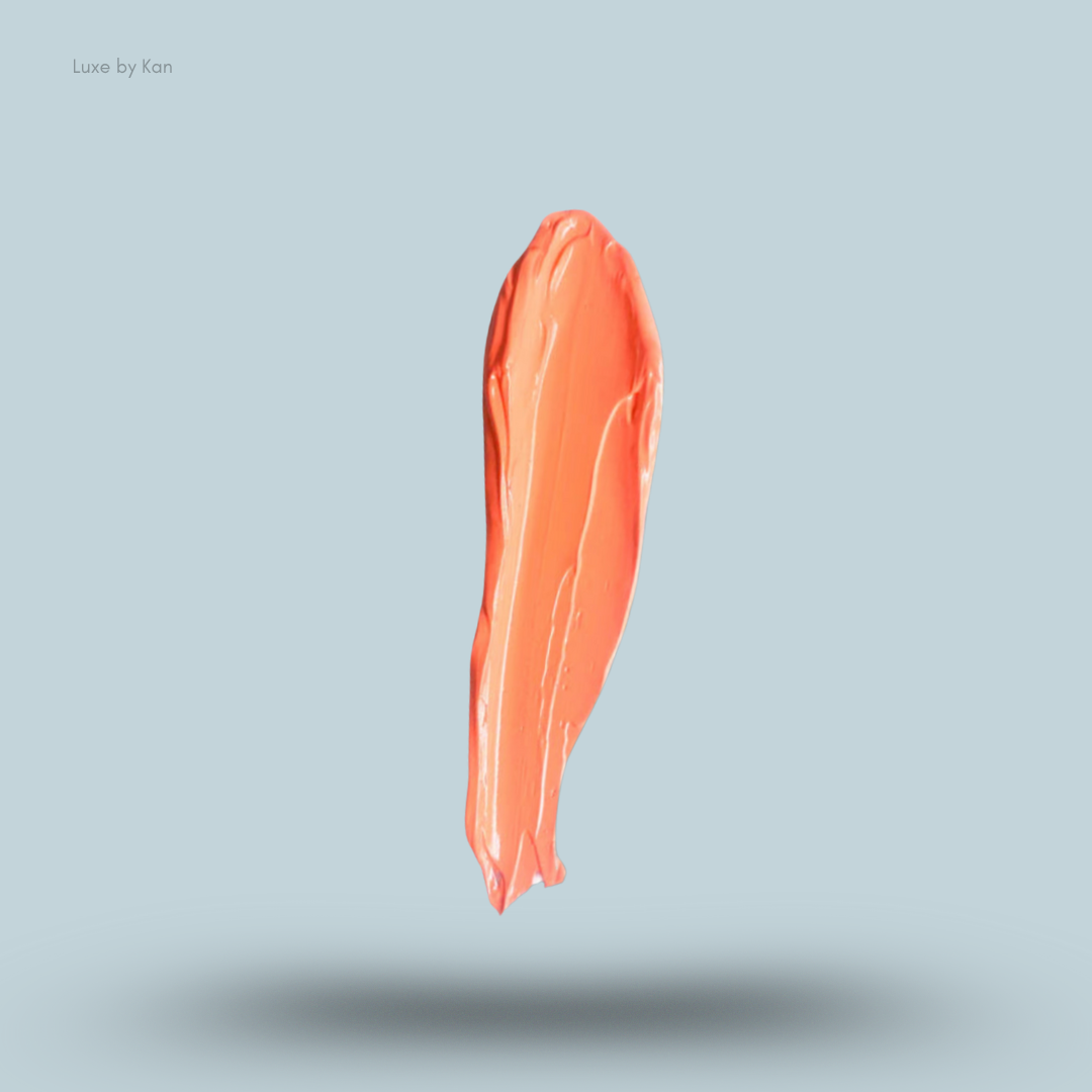 Close-up of a smear of Plouise colored base, coral hue, against a pale blue background.