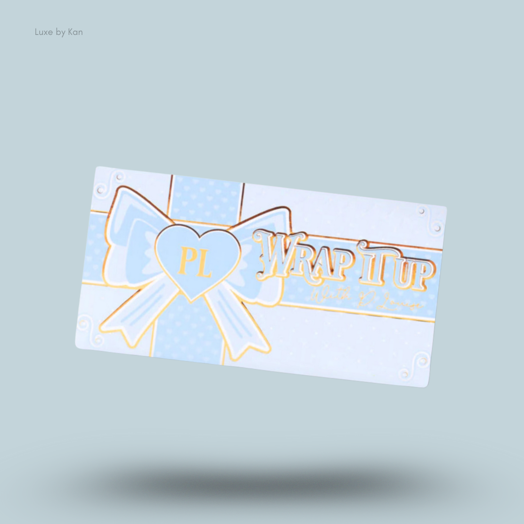 Plouise Wrap It Up bronzer palette packaging with illustrations of a ribbon, bow, and the product's name in gold-colored lettering.