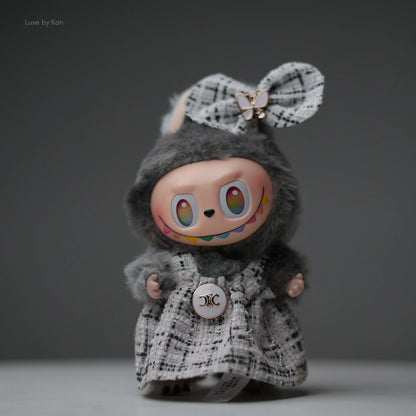 Pop Mart Labubu doll, gray flocked body with tweed dress outfit, bow, and rainbow smile.