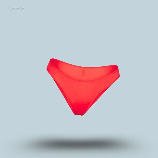 SKIMS Shine Foundations Dipped Bikini in Poppy, flat lay on light blue background