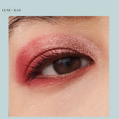 Close-up of a brown eye with shimmering rose and pink eyeshadow, accentuating the eyelid and lower lash line.