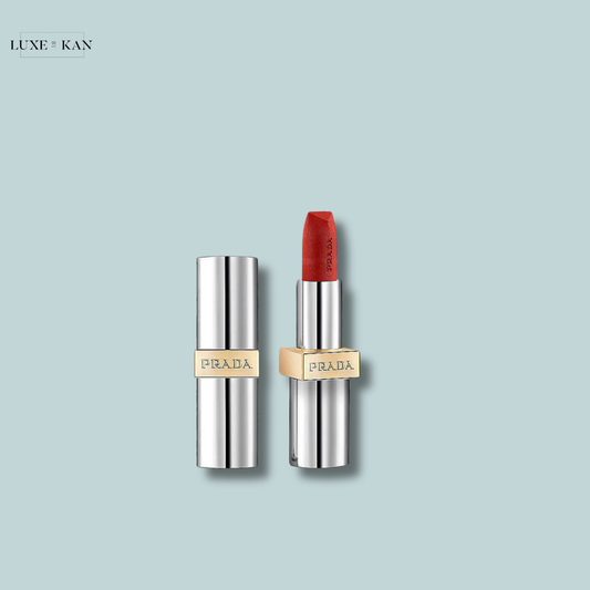 Close-up of a luxurious Prada lipstick in a sleek silver tube, featuring a bold red shade.