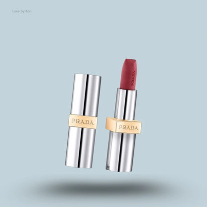 Prada hyper matte nude lipstick with a silver case and gold band, one with the cap off revealing the mauve lipstick.
