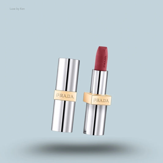 Prada hyper matte nude lipstick with a silver case and gold band, one with the cap off revealing the mauve lipstick.