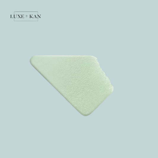 A smooth, triangular swatch of pale green cream sits against a soft blue background, branded with "Luxe & Kan" at the top.