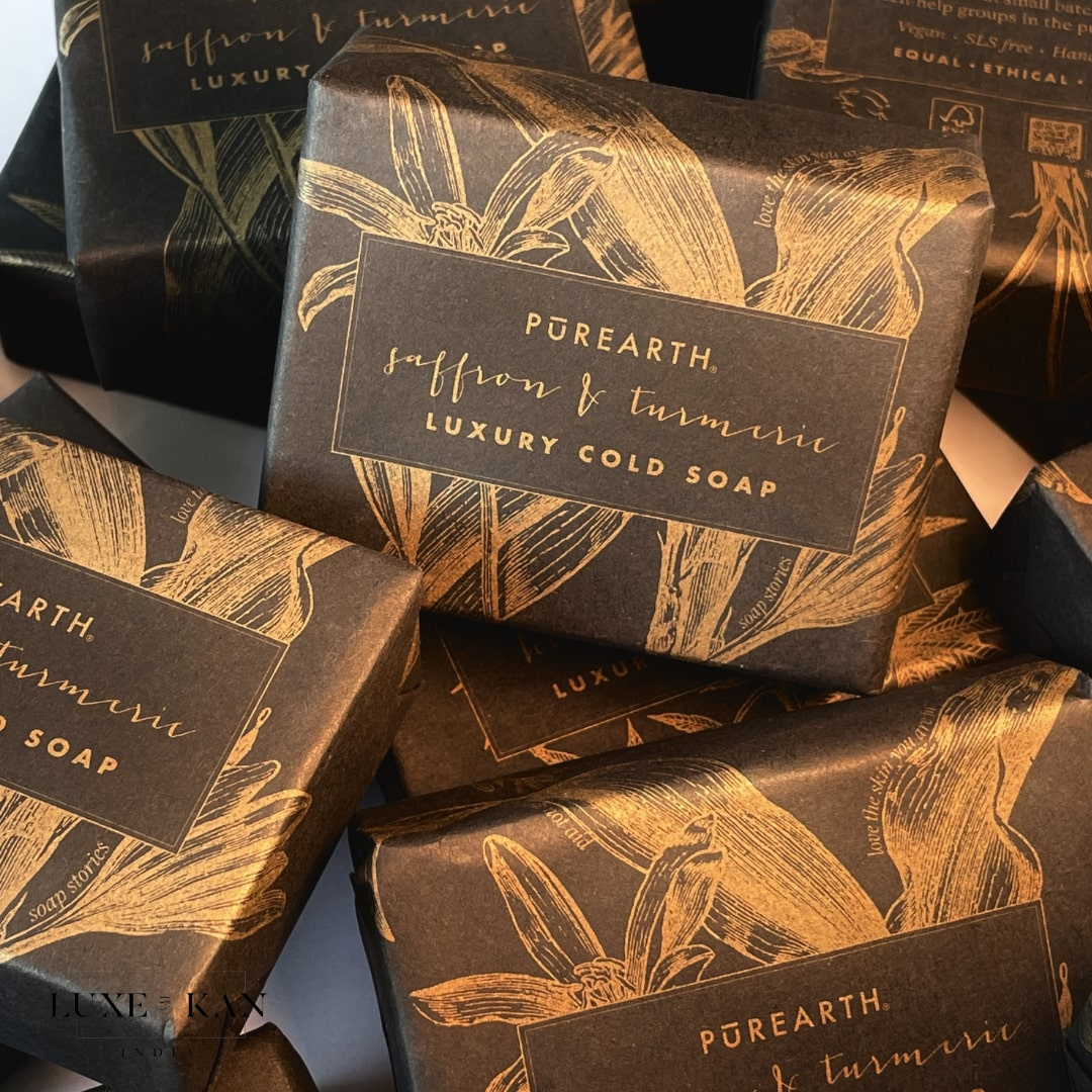 Luxurious packaging with gold floral design and text, "Pūrearth, Saffron & Turmeric Luxury Cold Soap."
