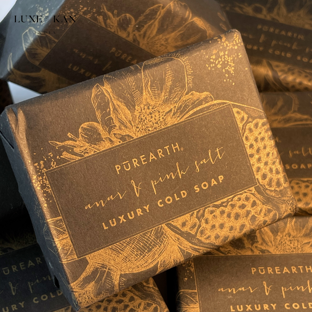 Luxurious packaging with gold floral design and text, "Pūrearth, Anar & Pink Salt Luxury Cold Soap."