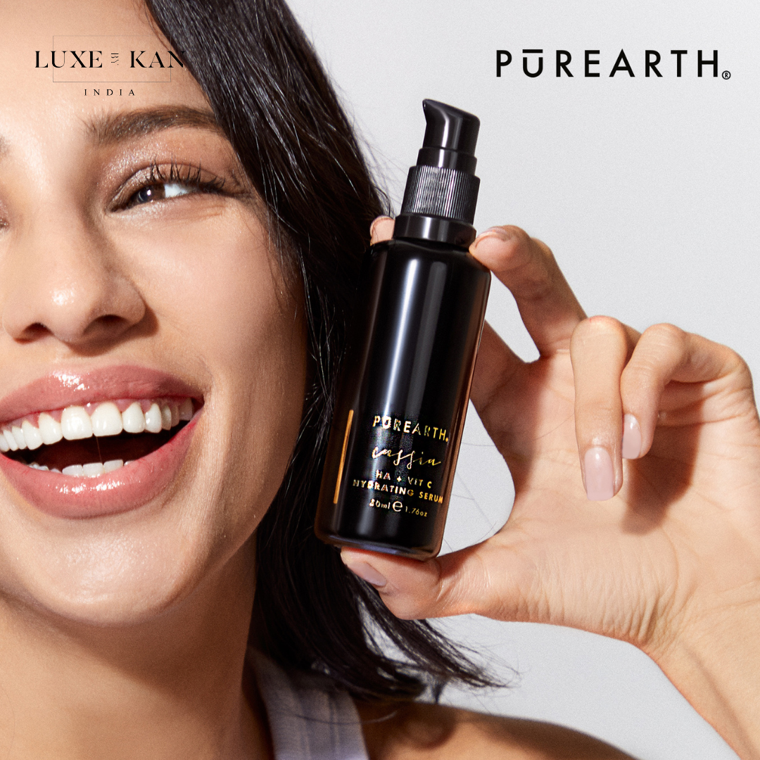 A person holds a sleek black bottle of Purearth HA + Vit C Hydrating Serum, showcasing the elegant design and label.
