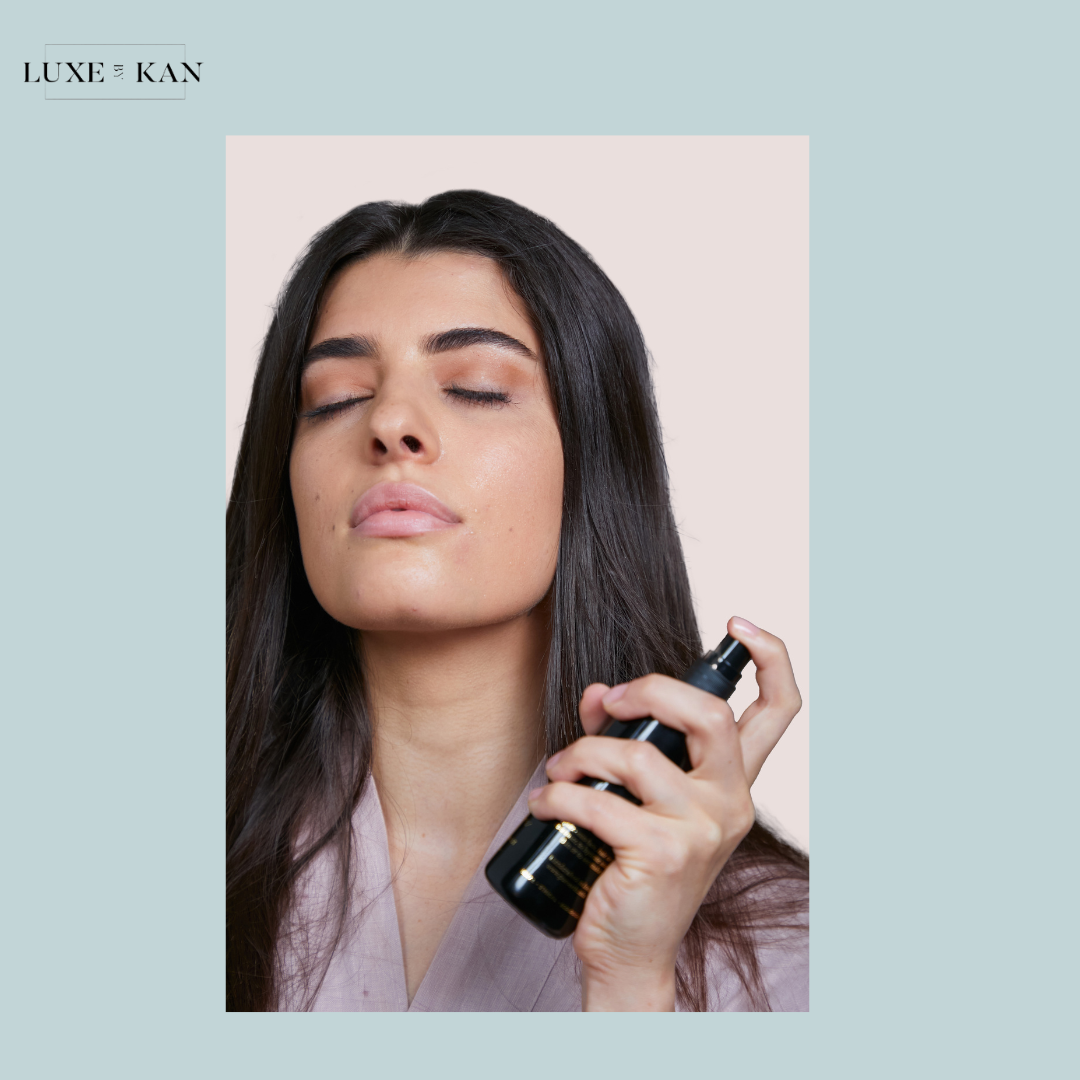 A person holds a sambac botanical essence bottle, showcasing long, shiny hair while wearing a light-colored robe.