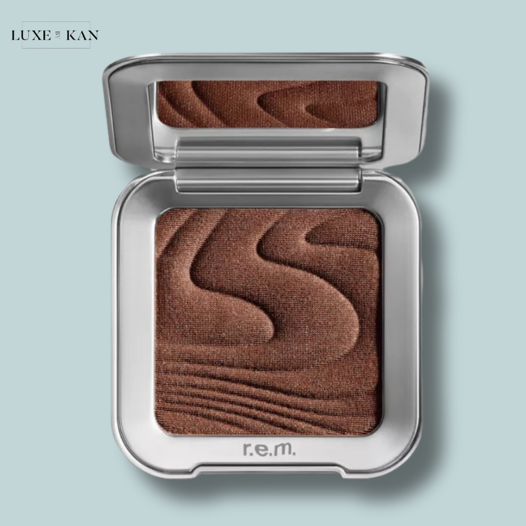 Rem Beauty hypernova satin matte bronzer compact in a sleek silver case, featuring a rich brown shade with textured waves on the surface.