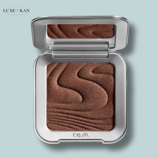 Rem Beauty hypernova satin matte bronzer compact in a sleek silver case, featuring a rich brown shade with textured waves on the surface.