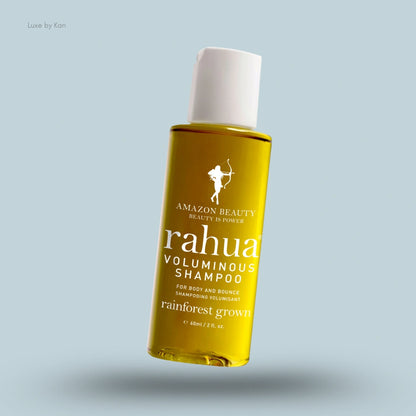 A bottle of Rahua voluminous shampoo, with its golden liquid contents visible through the clear plastic.