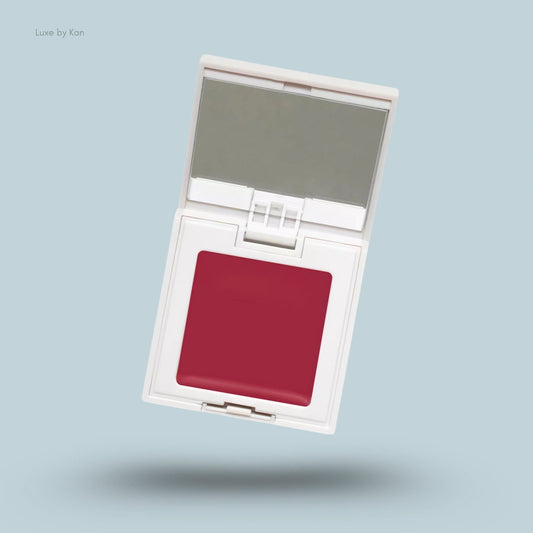 Refy cream blush in a white compact case, open to reveal a crimson cream blush and a mirror.