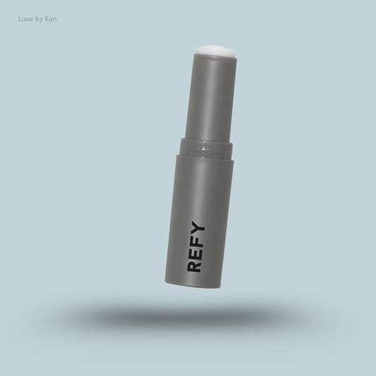 Refy eye balm in a gray tube with white balm visible at the top.