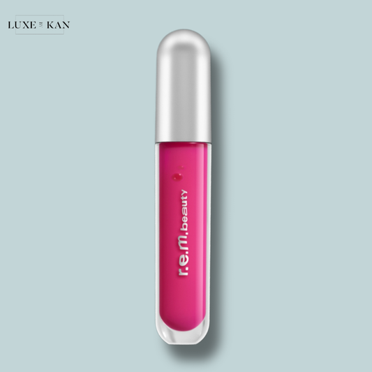 Essential drip glossy balm in a clear tube with a silver cap, labeled "r.e.m. beauty".