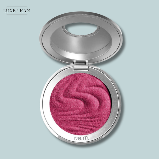 Open compact of r.e.m. beauty hypernova satin matte blush featuring a rich, marbled deep pink shade on a textured surface.