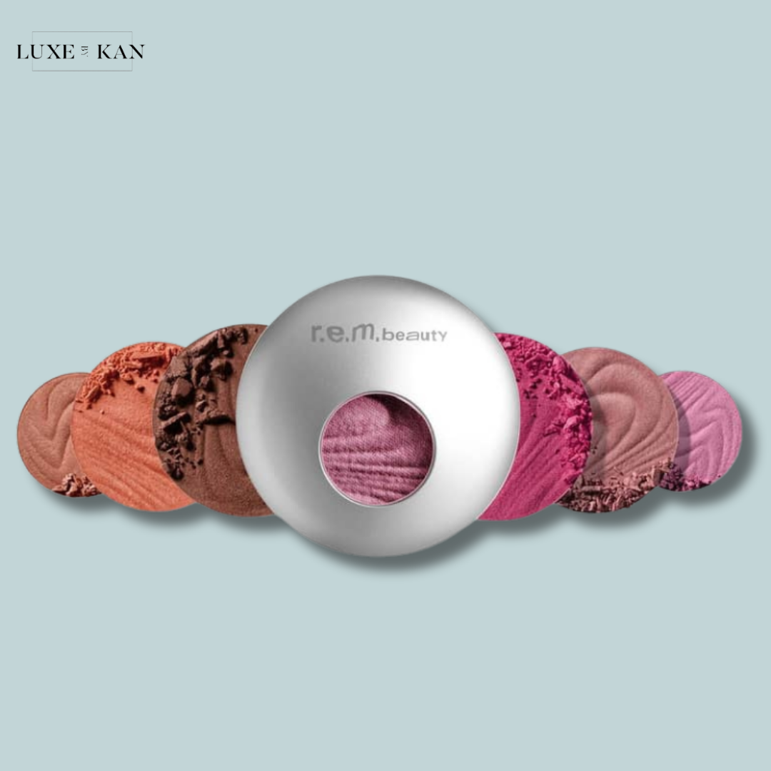 A sleek silver compact featuring various shades of r.e.m. beauty powders arranged in a circular pattern.