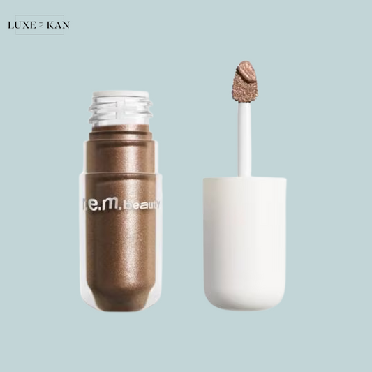 A midnight shadows liquid eyeshadow bottle with a white applicator wand, showcasing the r.e.m. beauty brand logo.