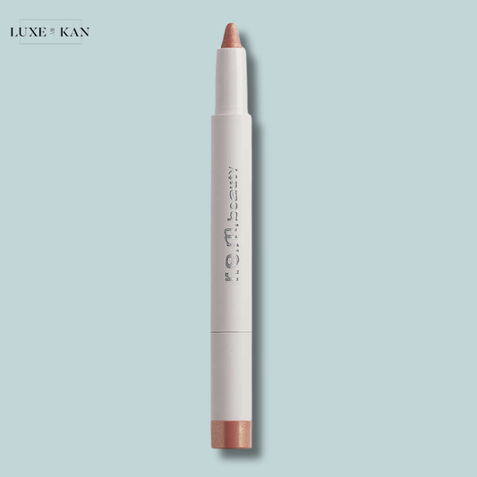 A sleek, midnight shadows multi-use eye stick with a peachy shimmer tip, featuring the brand name "r.e.m. beauty" in silver lettering.