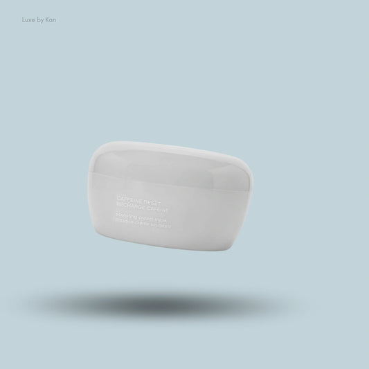 A white Caffeine Reset Sculpting Cream Mask jar by Luxe by Kan floats against a light blue background with a soft shadow.